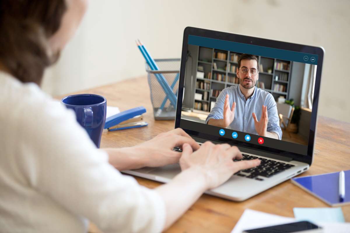 Back view of female employer talk interview confident male job applicant via online video call