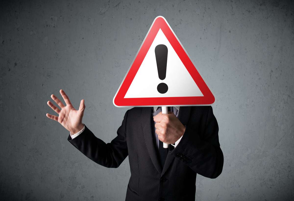 Businessman holding an exclamation road sign (R) (S)
